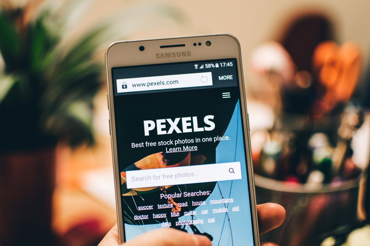 services-06 A close-up view of a smartphone displaying the Pexels website screen for stock photo searches.